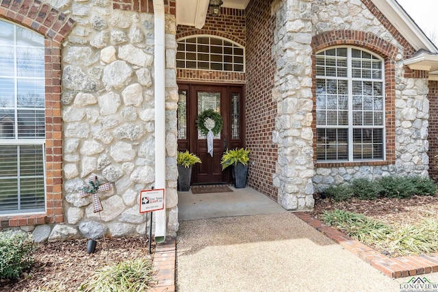 entrance to property with stone siding and brick siding