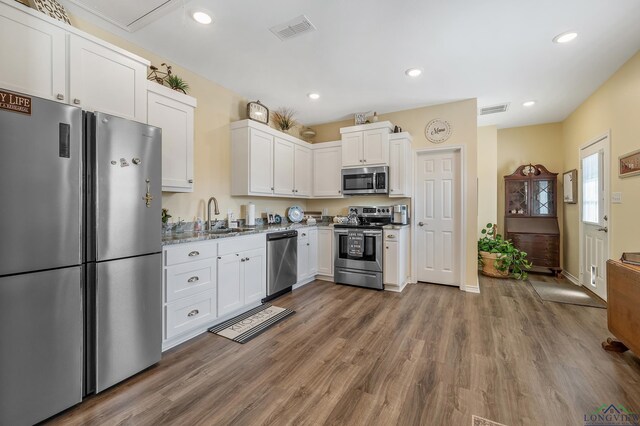 kitchen with stainless steel appliances, visible vents, a sink, and white cabinetry