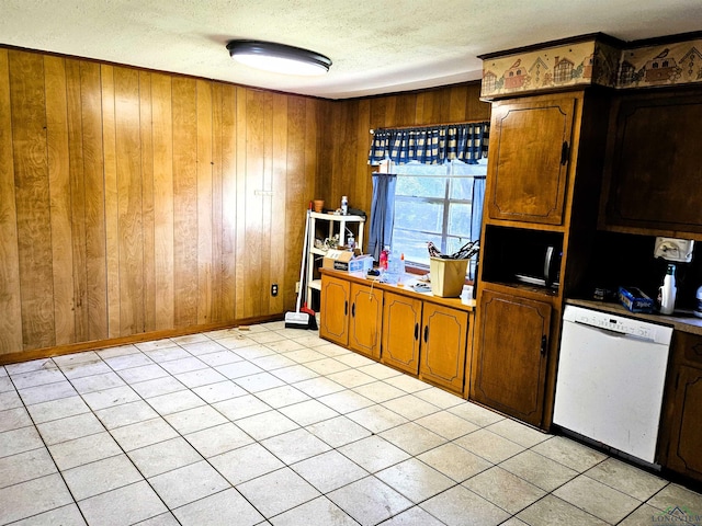 kitchen featuring dishwasher, a textured ceiling, and wooden walls