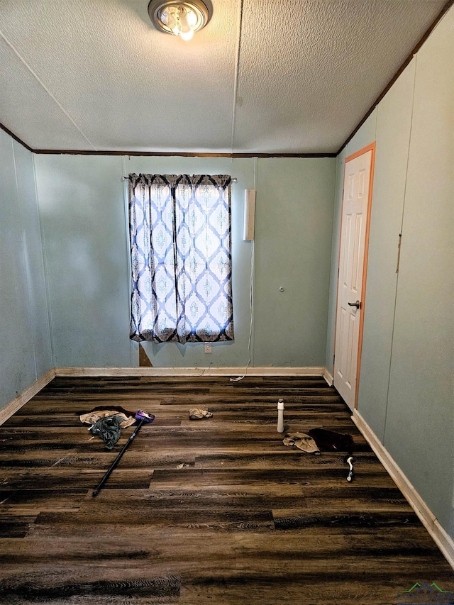 unfurnished room with dark hardwood / wood-style floors, crown molding, and a textured ceiling