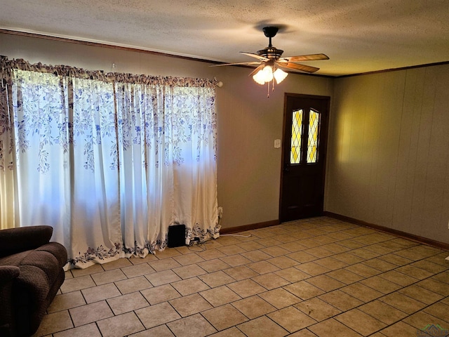 tiled spare room featuring ceiling fan, a textured ceiling, and wooden walls