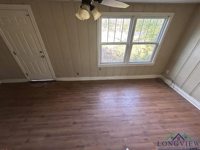 unfurnished dining area featuring dark wood-type flooring and ceiling fan