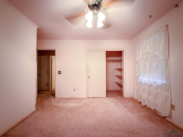 unfurnished bedroom featuring light carpet, a closet, ceiling fan, and crown molding