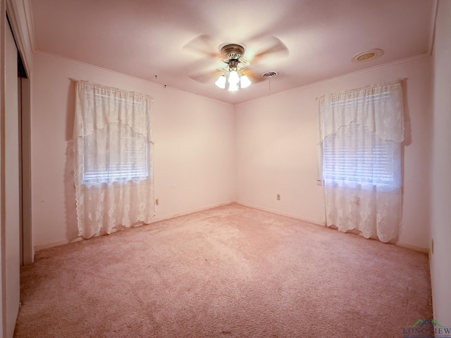 carpeted spare room featuring ceiling fan and ornamental molding