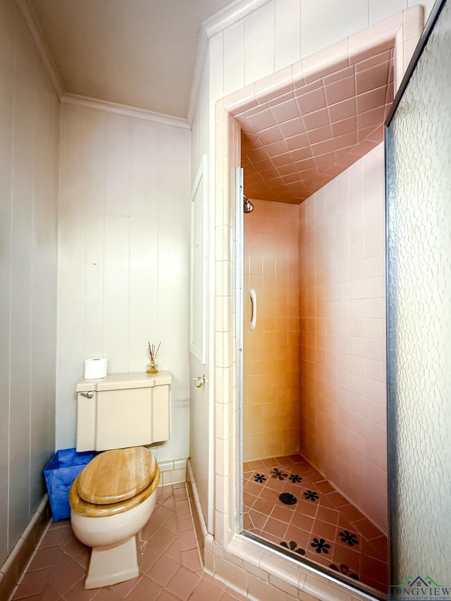 bathroom with tile patterned floors, toilet, ornamental molding, and a shower with door