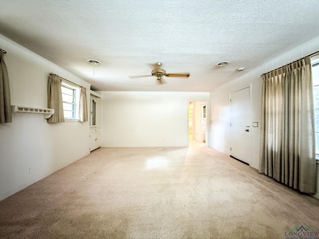 carpeted spare room featuring a textured ceiling and ceiling fan