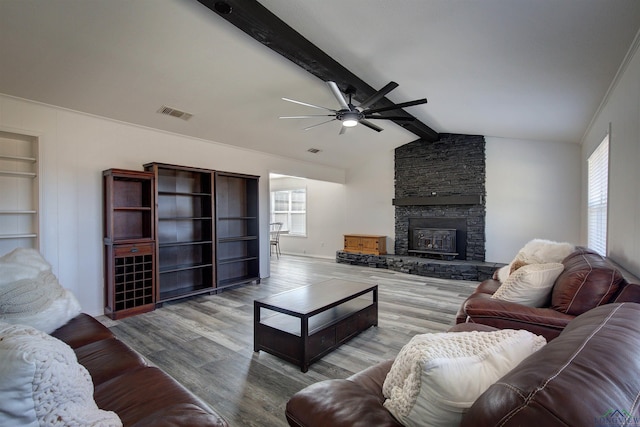 living room with a healthy amount of sunlight, a fireplace, light hardwood / wood-style floors, and built in features