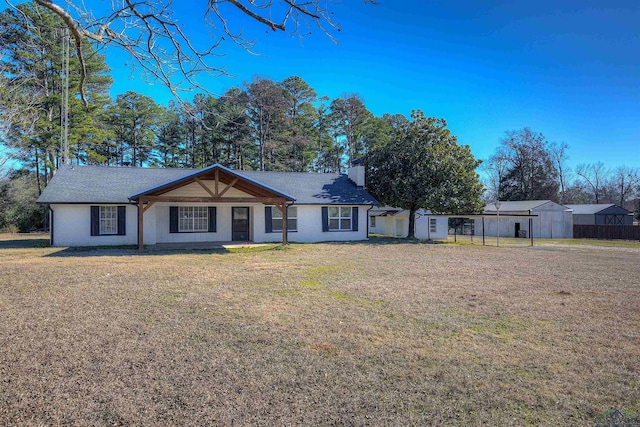 ranch-style house with a front yard and a storage shed