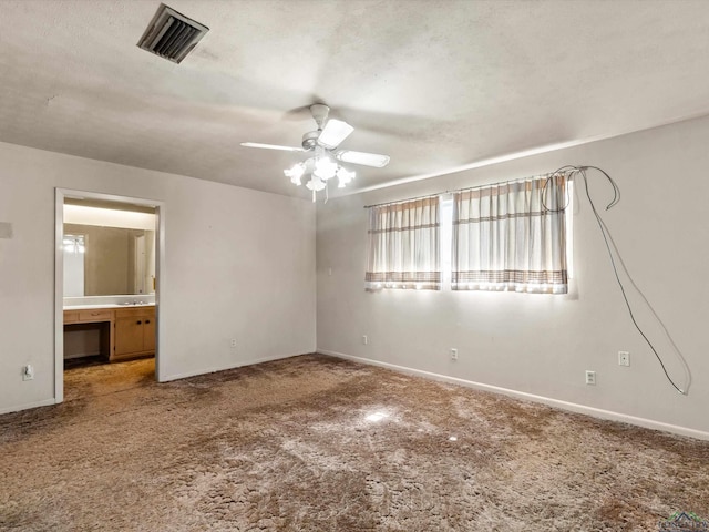 carpeted spare room featuring ceiling fan, a textured ceiling, visible vents, and baseboards