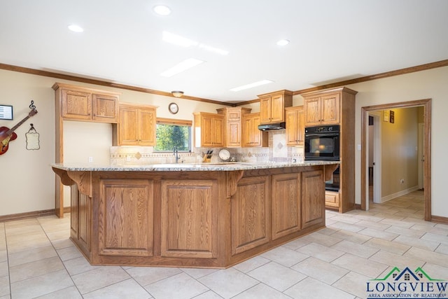 kitchen featuring black oven, a kitchen island, decorative backsplash, and ornamental molding