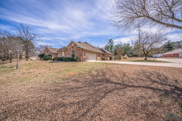 view of front of house featuring a garage, a front yard, brick siding, and driveway