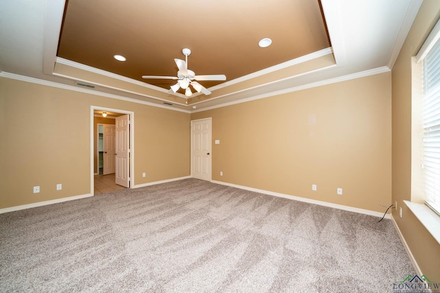 unfurnished room with carpet floors, baseboards, a tray ceiling, and ornamental molding