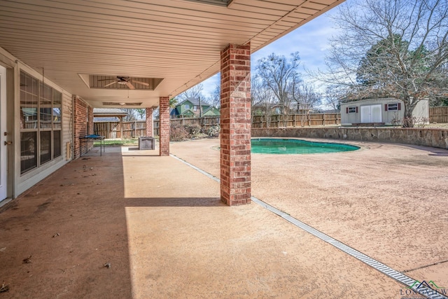 view of pool with a patio area, a fenced backyard, a storage shed, and an outbuilding