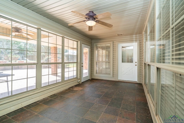 unfurnished sunroom featuring wooden ceiling and a ceiling fan