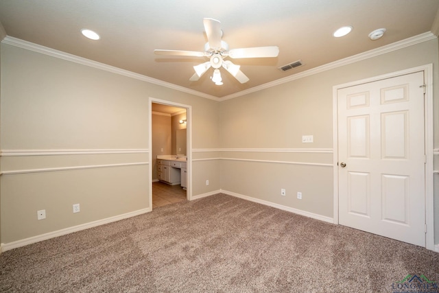 spare room with carpet floors, visible vents, ornamental molding, ceiling fan, and baseboards