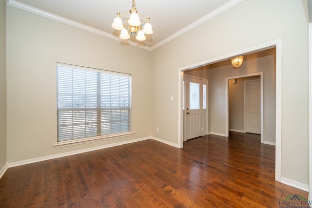 spare room with a chandelier, ornamental molding, wood finished floors, and baseboards