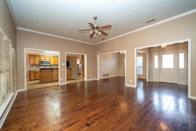 unfurnished living room featuring ornamental molding, dark wood finished floors, visible vents, and baseboards