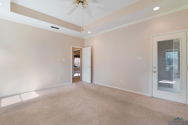 empty room featuring carpet flooring, ceiling fan, a raised ceiling, and ornamental molding