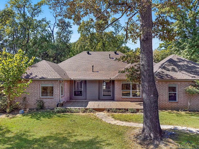 ranch-style house featuring a front yard and a deck