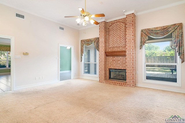 unfurnished living room featuring carpet flooring, crown molding, ceiling fan, and a brick fireplace