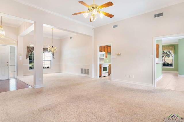 carpeted spare room featuring ceiling fan with notable chandelier and crown molding