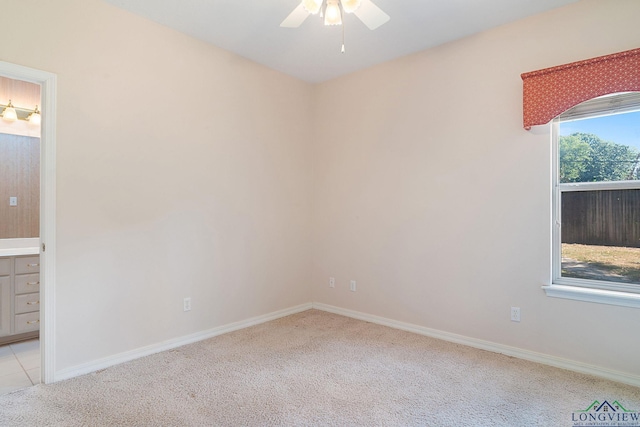 empty room featuring ceiling fan and light colored carpet