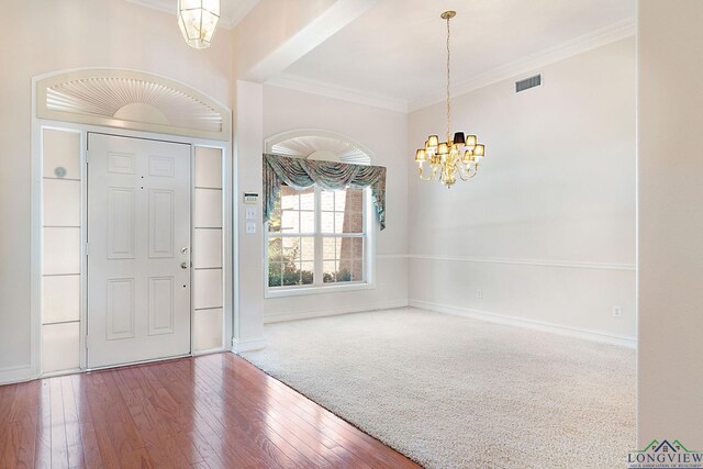 entryway with a chandelier, hardwood / wood-style flooring, and ornamental molding