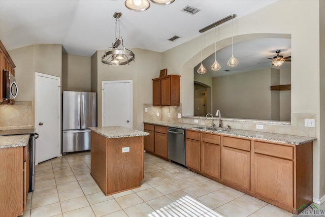 kitchen with backsplash, stainless steel appliances, ceiling fan, sink, and a kitchen island