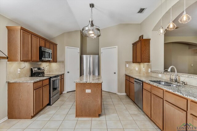 kitchen featuring sink, a center island, light stone counters, lofted ceiling, and appliances with stainless steel finishes