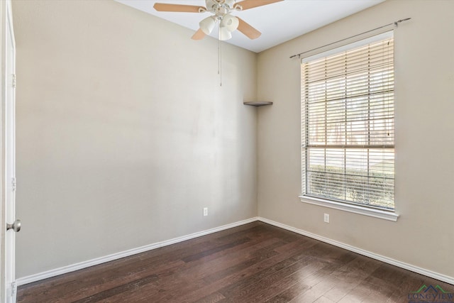 empty room with ceiling fan and dark hardwood / wood-style flooring