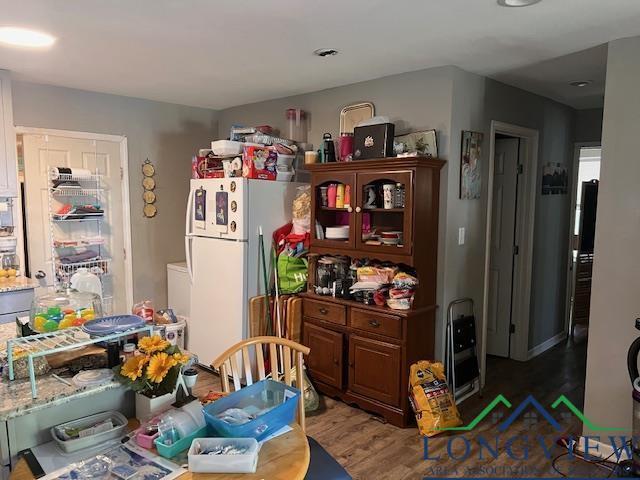 kitchen featuring wood finished floors and freestanding refrigerator