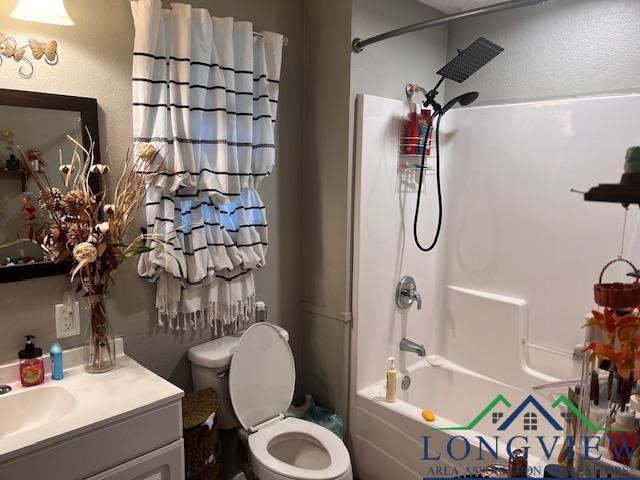 full bath featuring toilet, vanity, and tub / shower combination