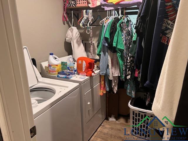 washroom with light wood-style flooring, washing machine and clothes dryer, and laundry area