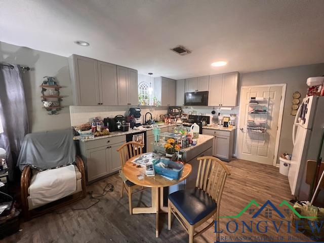 kitchen with light countertops, black microwave, visible vents, and gray cabinets