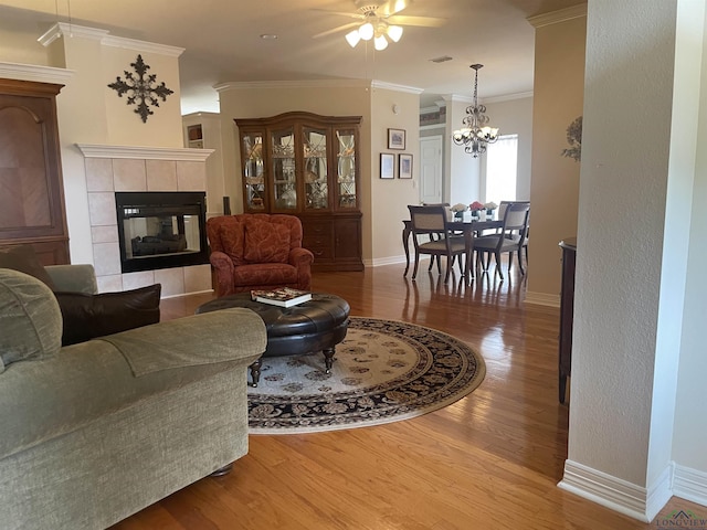 living room featuring ceiling fan with notable chandelier, light hardwood / wood-style floors, and ornamental molding