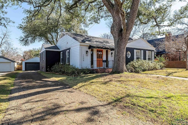 view of front of property featuring an outbuilding, a garage, and a front lawn