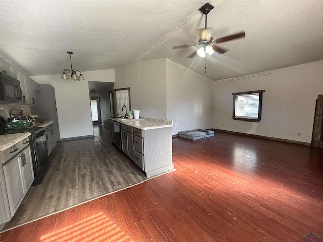 kitchen with sink, dark wood-type flooring, pendant lighting, black appliances, and ceiling fan with notable chandelier