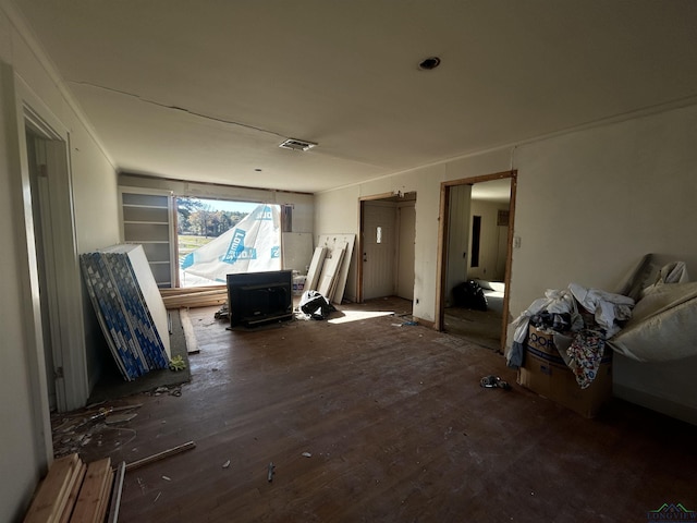 miscellaneous room with a wood stove and dark wood-type flooring