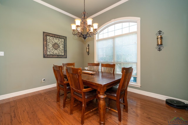 dining area with hardwood / wood-style flooring, a notable chandelier, and ornamental molding