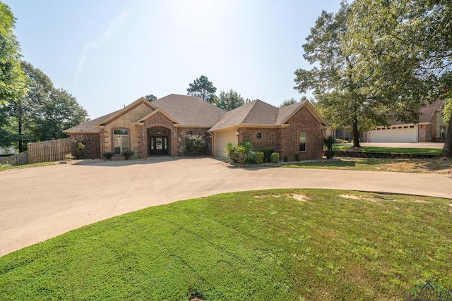 single story home with a garage and a front lawn