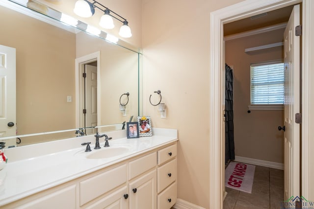 bathroom with crown molding, tile patterned flooring, and vanity