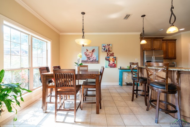 dining space with light tile patterned floors and crown molding