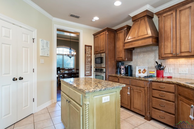 kitchen with backsplash, appliances with stainless steel finishes, a notable chandelier, a kitchen island, and custom range hood