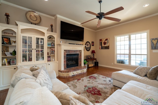 living room with ceiling fan, crown molding, a fireplace, and dark wood-type flooring