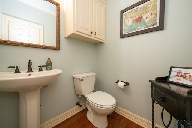 bathroom with crown molding, toilet, wood-type flooring, and sink