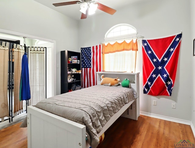 bedroom with a ceiling fan, baseboards, and wood finished floors