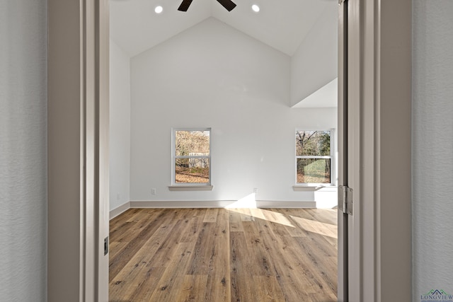 interior space featuring ceiling fan, high vaulted ceiling, and light hardwood / wood-style flooring