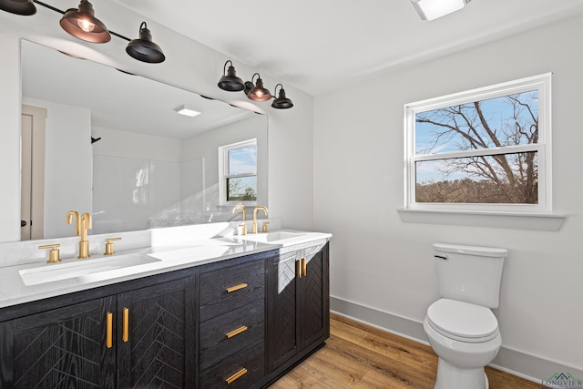 bathroom featuring a shower, hardwood / wood-style floors, vanity, and toilet