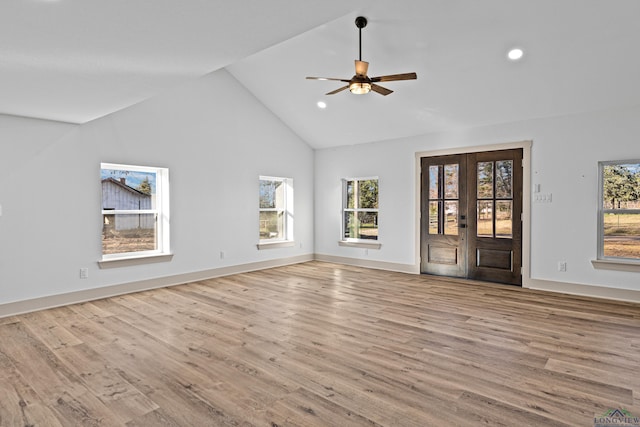 unfurnished living room featuring ceiling fan, light wood-type flooring, high vaulted ceiling, and french doors