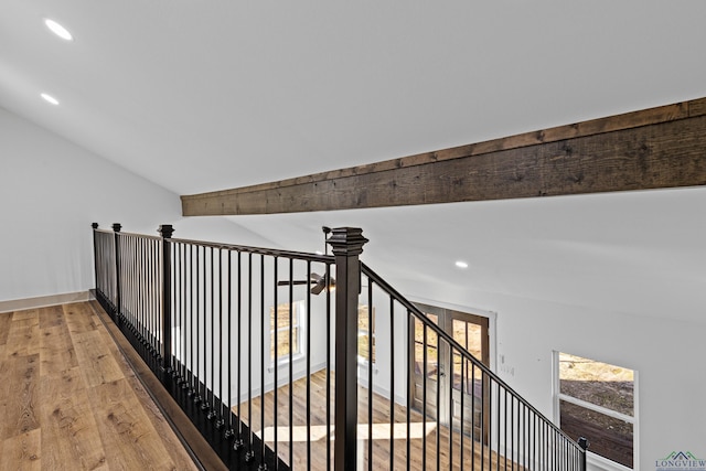 hall with lofted ceiling with beams, light hardwood / wood-style flooring, and a healthy amount of sunlight